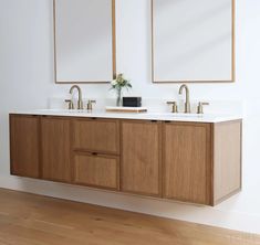 a bathroom with two sinks and mirrors on the wall next to each other in front of a wooden floor