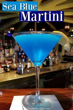 a blue martini sits on a bar with the words sea blue martini in front of it