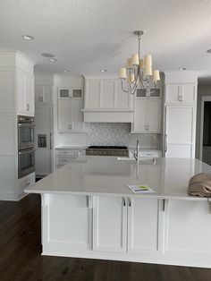 a large kitchen with white cabinets and an island