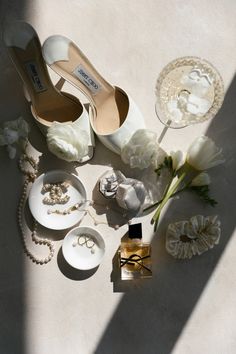 wedding accessories including shoes, jewelry and flowers are laid out on the floor next to each other