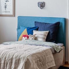 a bed with blue headboard and pillows on it