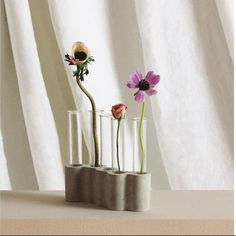 three vases with flowers in them sitting on a table