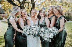 a group of women standing next to each other in front of a tree with flowers