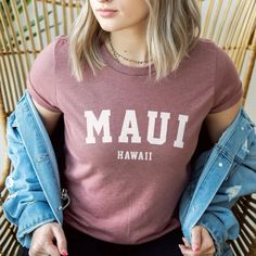 a woman sitting in a chair wearing a mau hawaii t - shirt