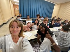 a group of people sitting at desks in a classroom