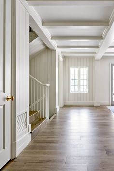 an empty room with wood floors and white walls