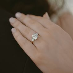 a woman's hand with a diamond ring on it