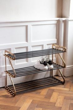 a pair of shoes sitting on top of a metal rack next to a wall mounted shoe rack