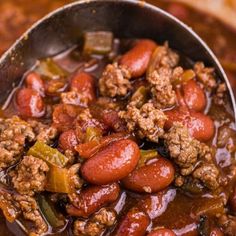 a spoon full of chili and beans with meat