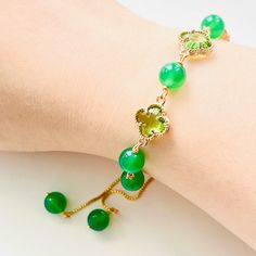 Add a touch of luck and style to your outfit with our Green Clover Beaded Bracelet. Made with vibrant green agate beads and delicate glass four-leaf clovers, this bracelet is not only a beautiful accessory but also a symbol of good fortune. Share the luck with a friend by gifting them this special bracelet! Dimensions: Adjustable Materials: Gold-plated brass, green agate, glass Elegant Green Crystal Bracelet With Natural Stones, Elegant Green Crystal Gemstone Bracelet, Green Bangle Crystal Bracelet With Natural Stones, Green Natural Stones Crystal Bangle Bracelet, Elegant Green Beaded Bracelets With Natural Stones, Elegant Green Bracelet With Round Beads, Elegant Adjustable Green Crystal Bracelet, Green Clover, Lucky Bracelet