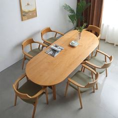 a wooden table with chairs around it and a plant in the corner on top of the table