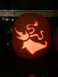 two carved pumpkins sitting on top of a counter