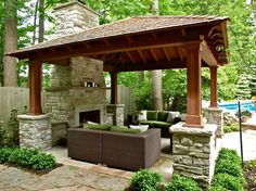 an outdoor living area with couches and a fireplace