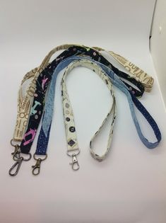 several lanyards are lined up on a white surface with blue and pink designs