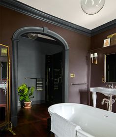 a bath room with a tub a sink and a mirror on the wall in it