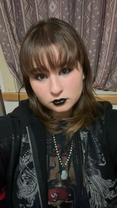 a young woman with black lipstick on her lips