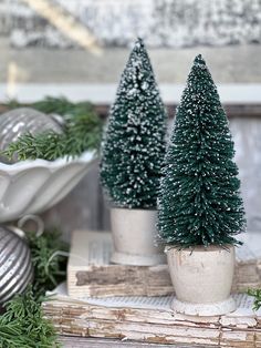 three small christmas trees sitting on top of books