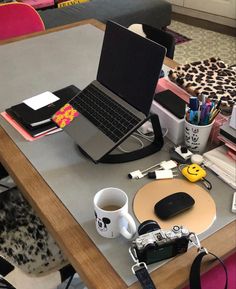 a laptop computer sitting on top of a wooden table next to a cup of coffee