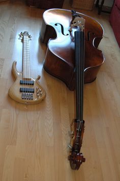 a violin and an electric guitar sit on the floor in front of each other,