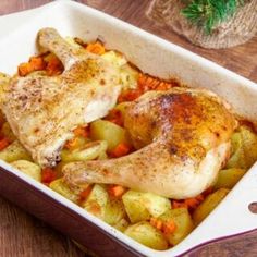 chicken and vegetables in a casserole dish on a wooden table