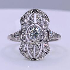 Art Deco Platinum ring with one 0.52 carat center Old European Cut diamond and 0.27 carat total weight accent diamonds. Style includes fine filigree details throughout. Material: Platinum Diamonds:  (1) One 0.52 carat center Old European Cut diamond (2) 0.27 carat total weight accent diamonds Setting: bezel and bead set stones Size: 7.5 US / O 1/2 UK / 55-56 EU Style: Art Deco, Antique, Vintage Condition: Gently-Preowned and Professionally Cleaned and Polished Formal Art Deco Diamond Ring With Pave Setting, Heirloom Diamond White Diamond Ring With Pave Setting, Heirloom Diamond White Ring With Pave Setting, Art Deco Diamond Ring With Pave Setting For Anniversary, Art Deco Diamond Ring With Center Stone, Classic White Diamond Ring With Intricate Design, Art Deco Wedding Rings With Pave Setting, Art Deco White Gold Ring With Pave Setting, Art Deco White Gold Rings With Pave Setting