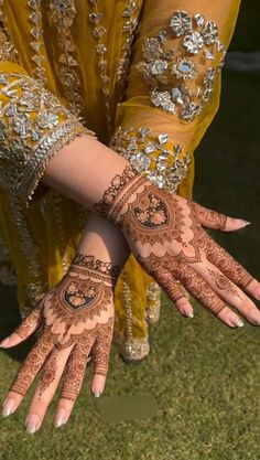 the hands and arms of a woman with henna tattoos