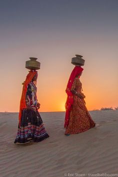 two women walking in the desert at sunset