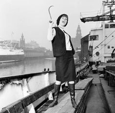 a woman holding an umbrella on the deck of a ship