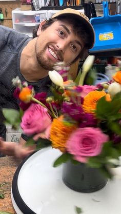 a man is smiling next to a bouquet of flowers