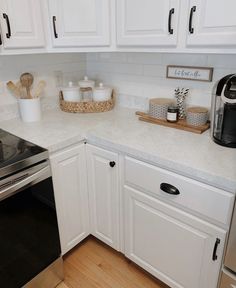 a kitchen with white cabinets and stainless steel appliances