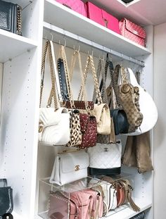 purses and handbags are hanging on shelves in a closet with white shelving