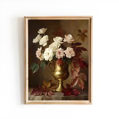 a gold vase filled with white and pink flowers