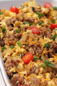 a casserole dish with sausage, eggs and tomatoes