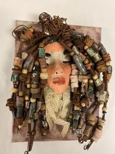 a sculpture made out of old bottles and other items on a white wall with a man's head in the middle