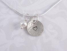 "This necklace has a heart hand stamped on a hammered sterling silver 3/8\" charm.  A white pearl hangs with it. Thanks for looking :)"