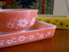 two pink bowls sitting on top of a wooden table