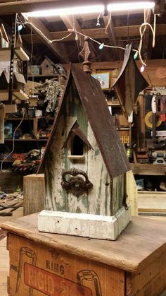 a birdhouse made from an old wooden box is on display in a shop with lots of other items