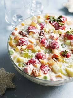 a bowl filled with fruit and nuts on top of a table next to a starfish