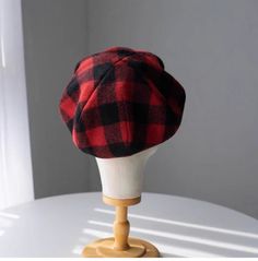 a red and black plaid hat sitting on top of a white table