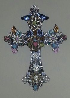 a cross with many different colored stones on it