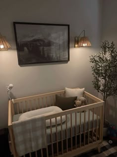 a baby's room with a crib, lamp and pictures on the wall