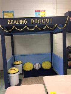 a reading dugout with balls and buckets on the bottom shelf for children to play in