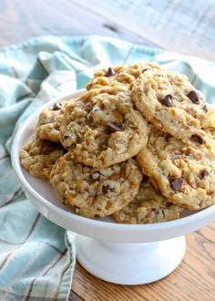 chocolate chip cookies in a white bowl on a table with a blue and white towel