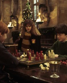 harry potter and hermione's hogwarts chess game in front of the christmas tree