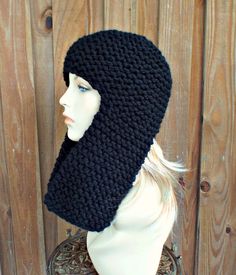 a mannequin head wearing a black knitted hat on top of a wooden table