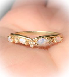 a gold ring with opal and diamonds on it