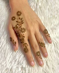 a woman's hand with hennap on it and flowers painted on the fingers