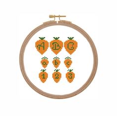 a cross stitch pattern with oranges and letters in the shape of pumpkins on a white background