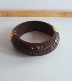 Chunky BOHO carved brown wood domed bangle bracelet with brass inlay. 2.5 inches inner diameter.; 1 inch tall, 0.5 inches thick. Good condition.   MPORTANT TO READ: To make this a smooth and pleasant transaction experience for everyone, all buyers need to read and understand the description, the terms of sale , the payment and the shipping indicated in this listing. TERMS OF SALE A. SHIPPING WORLDWIDE This listing includes payable tracked services with the fees indicated below. B. CARRIERS We do Handmade Brown Round Bangle, Traditional Handmade Brown Bangle, Traditional Brown Bangle Jewelry, Brown Carved Bangle Bracelets, Brown Carved Bracelet Jewelry, Vintage Carved Brown Bracelets, Vintage Brown Carved Bracelets, Carved Brown Bangle Jewelry, Brown Carved Bangle Jewelry