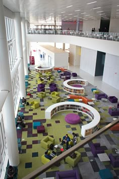 the interior of an office building with colorful carpeting and seating area, as well as several people sitting on couches